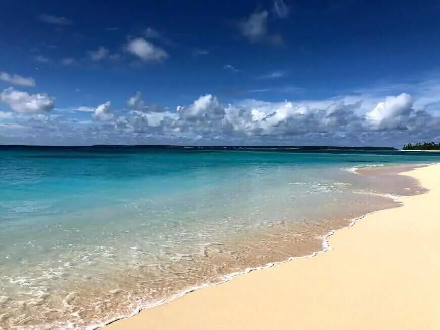 A sandy beach with blue water for an adventurous experience.
