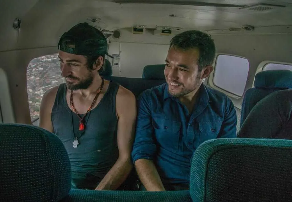 Three men sitting in the private back of a plane.