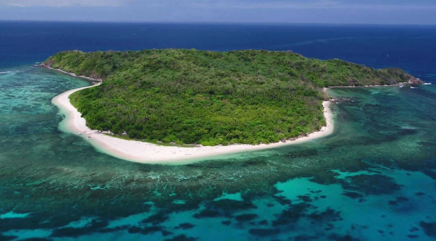 An adventurous aerial view of an island surrounded by the vast ocean.