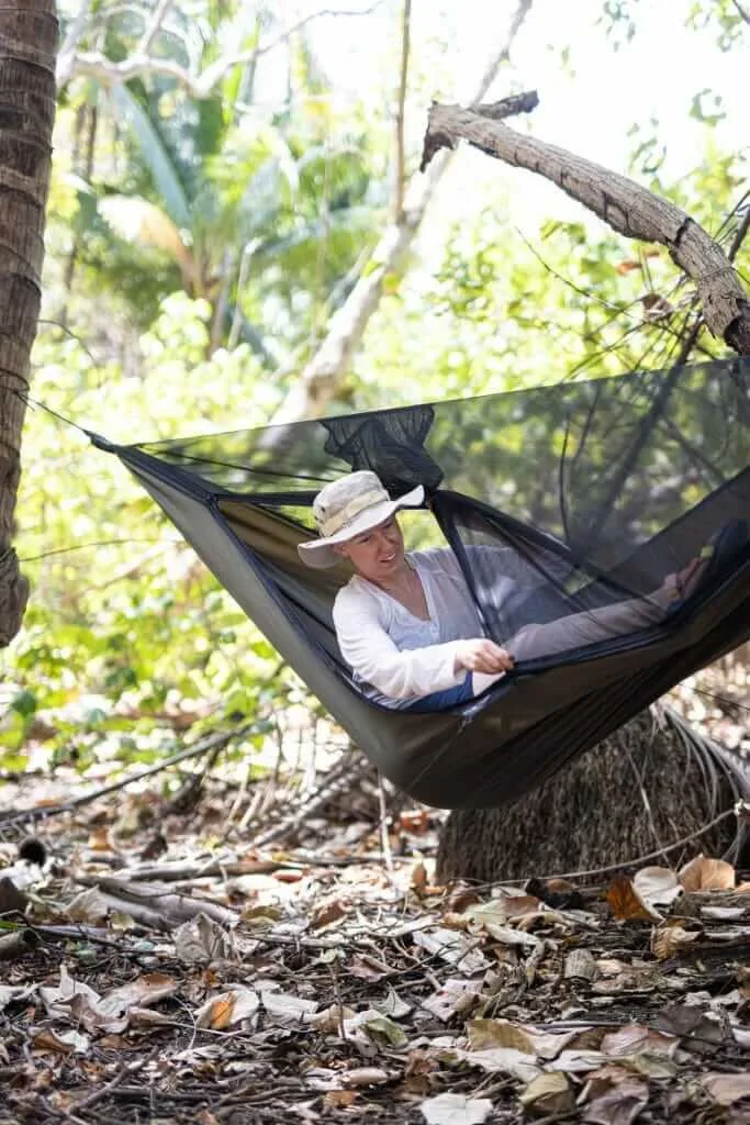 A woman relaxing in a hammock in the woods.