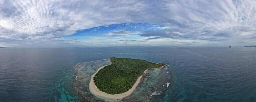 A fish eye view of an island in the ocean.