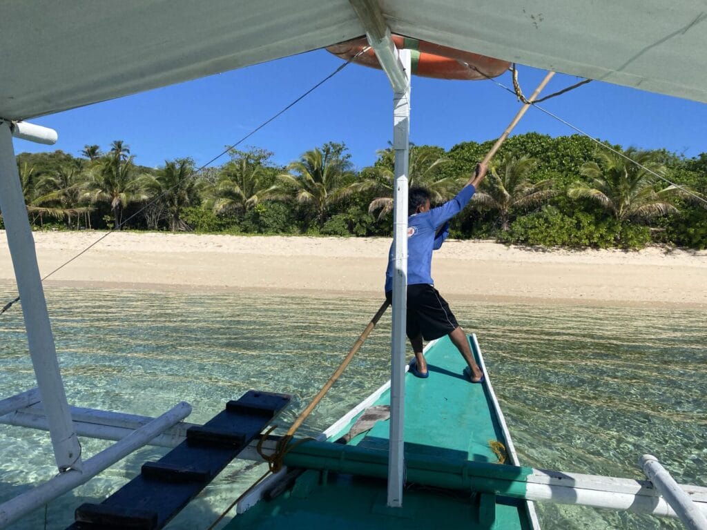 Man on boat arriving at a tropical island