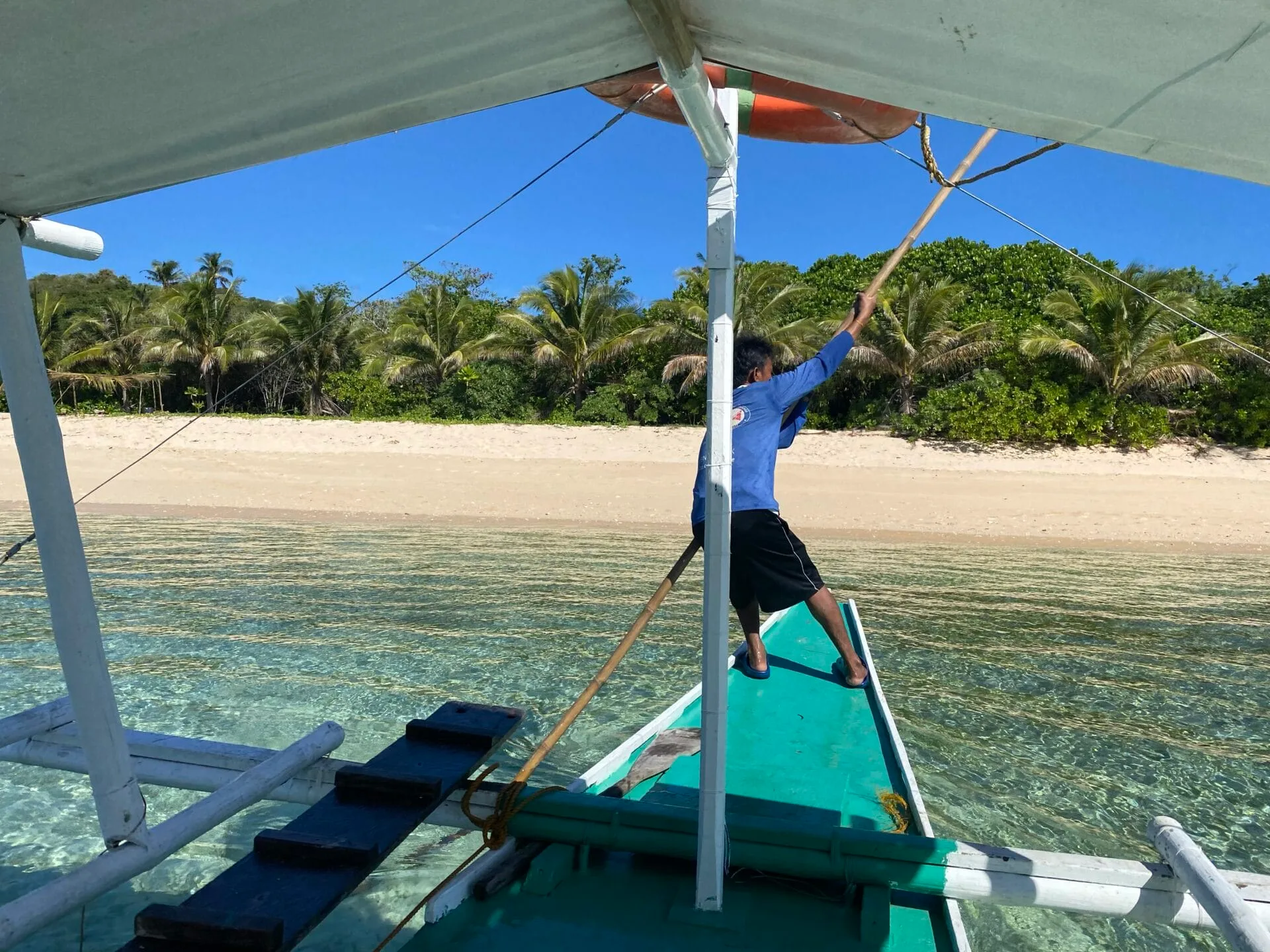 Man on boat arriving at a tropical island