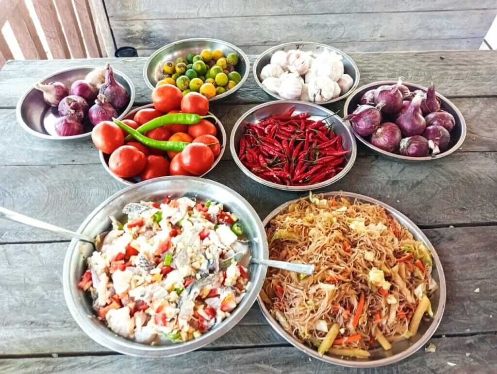 Various bowls of food on a wooden table.