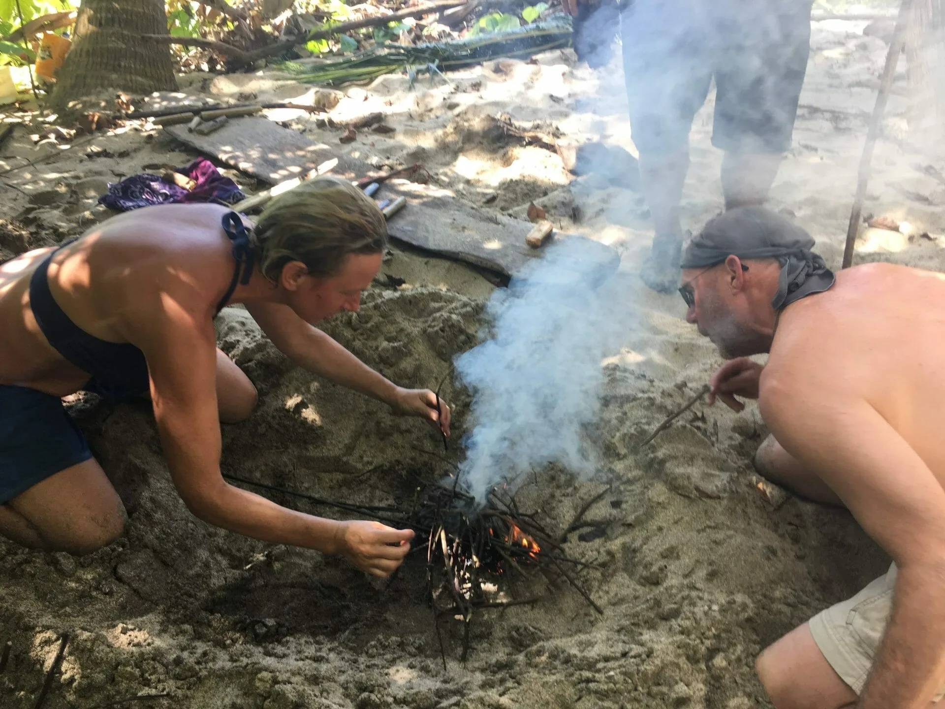 Woman and man making fire on a beach