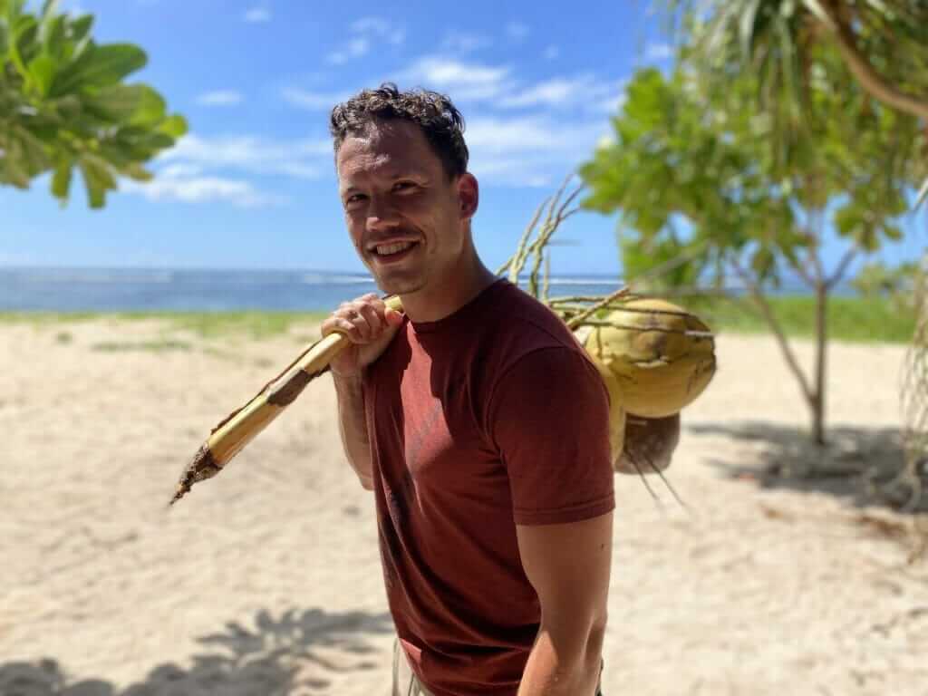Man carrying coconuts on the beach