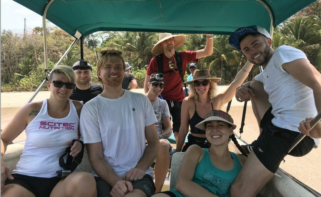 Happy people on a boat with beach in the background