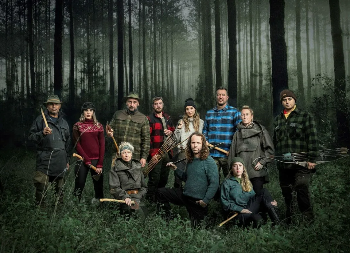 Cast of Alone UK survival show, standing in a forest setting.