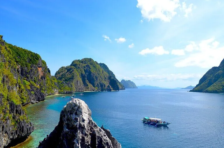 Scenic view of Coron in Palawan with islands, turquoise water, and a boat.
