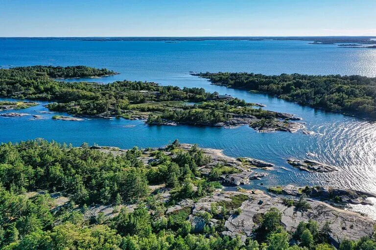 Sweden archipelago aerial view. Islands with trees and rocky shores in blue water.
