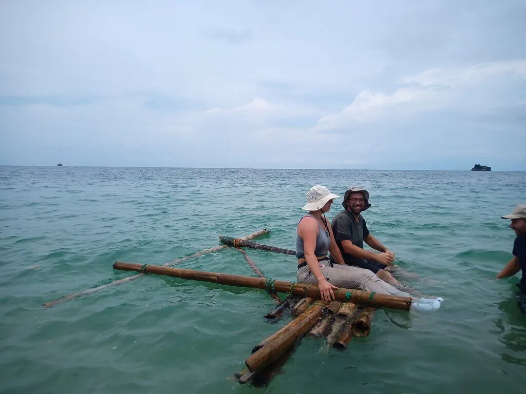 Two people sitting on a self-made raft