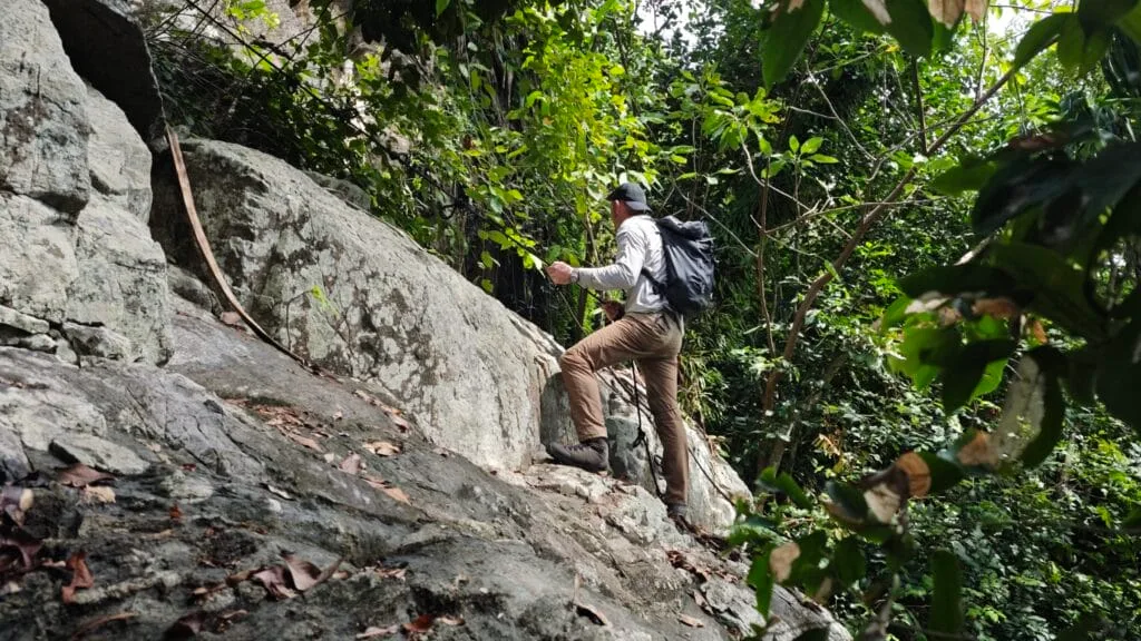 man climbing up rocks