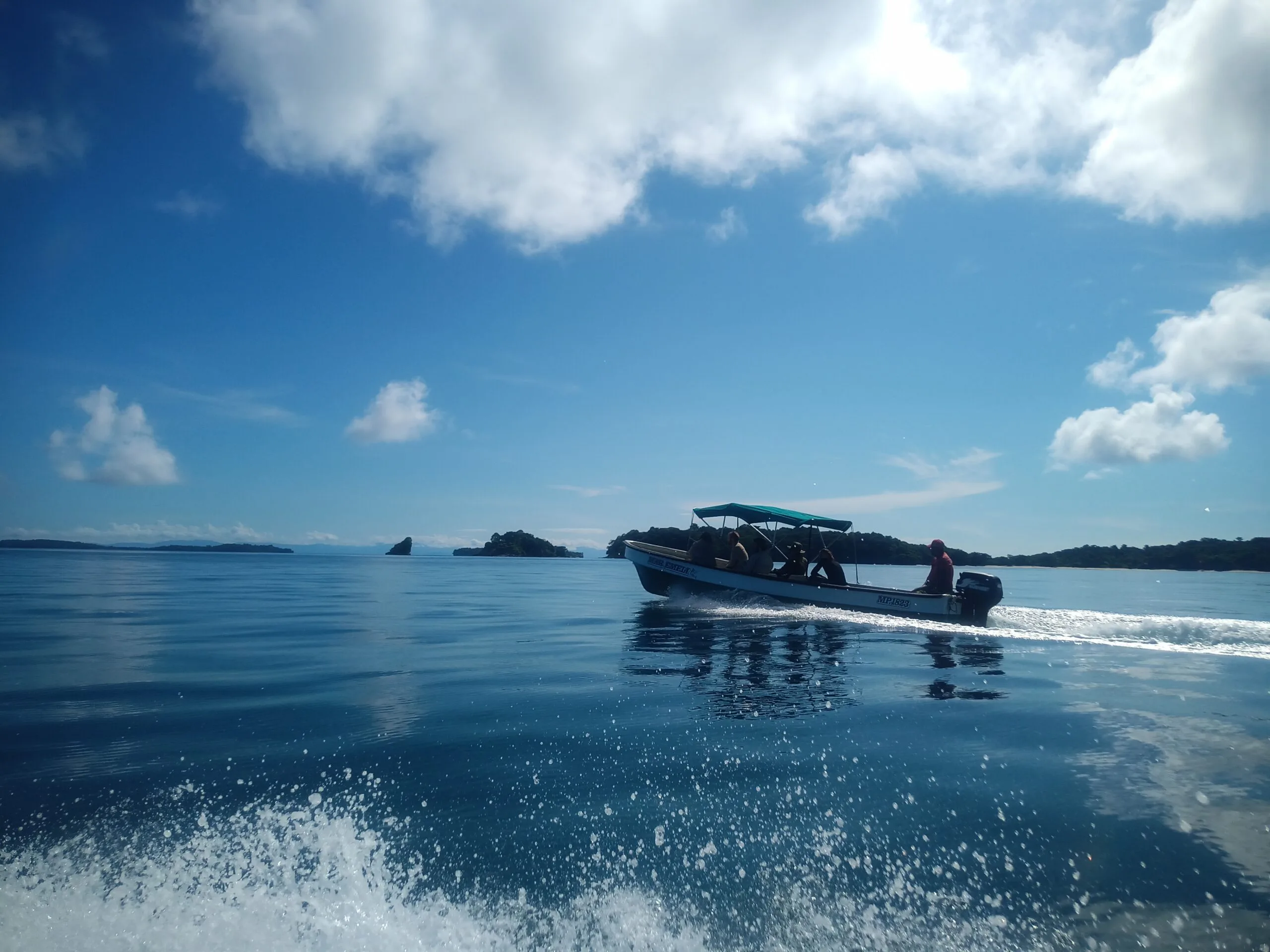 Speedboat on turquoise water with islands, ideal for corporate team building adventures.