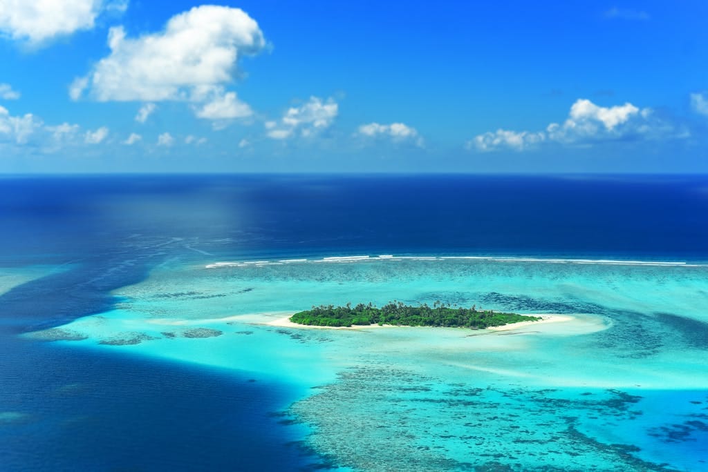 The Best Remote Holiday Destinations for Unforgettable Adventures 4 A stunning aerial view captures a lush island surrounded by turquoise waters in the Maldives.