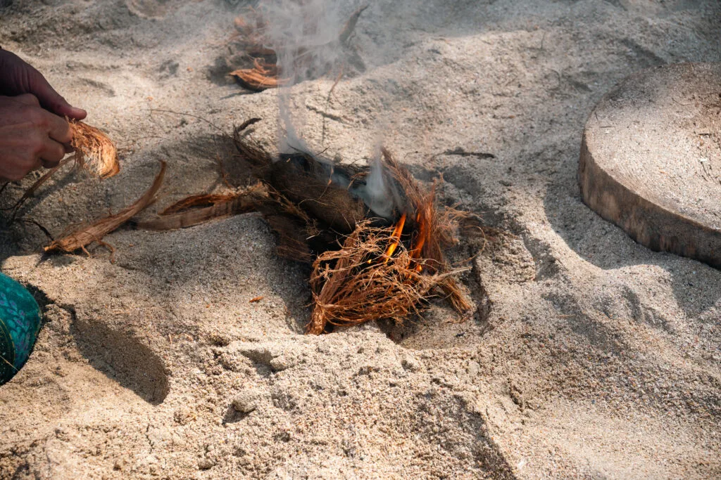 Starting a fire with coconut husk as tinder. Learn how to start a fire with a bow drill.