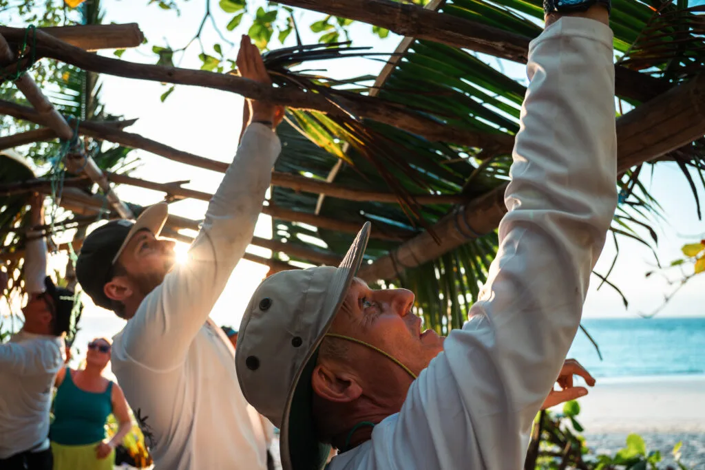 People building a beach structure, escaping without technology.