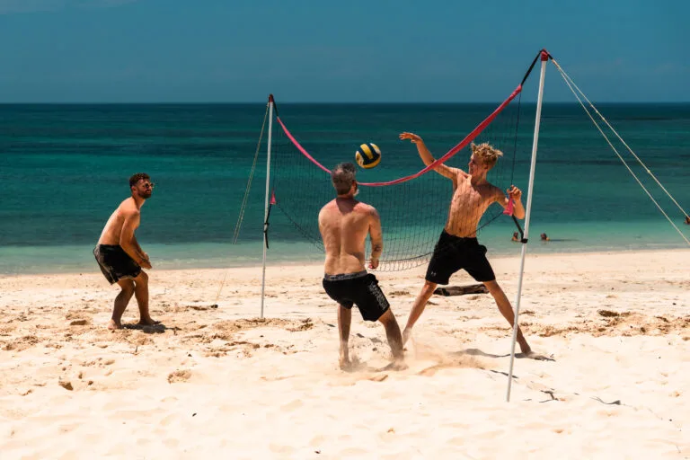Men playing beach volleyball on a sunny day. Perfect for "Private Adventures"!