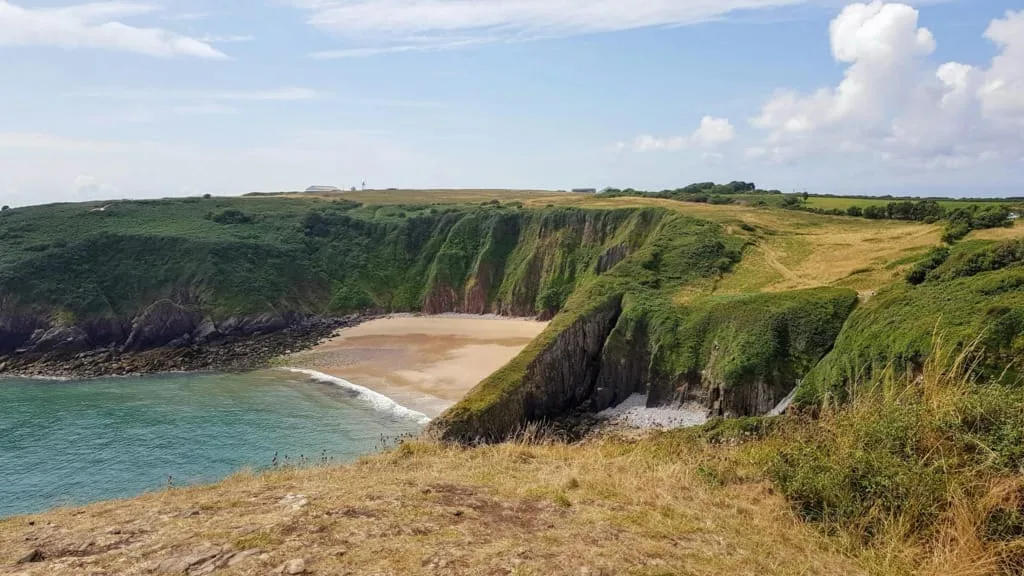 Beautiful coastal landscape of Manorbier Beach, Wales with cliffs and ocean view.