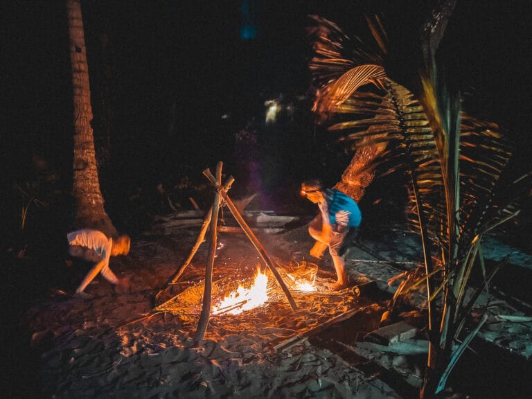 Private Group Adventures 9 Survival skills on a deserted island, building a campfire at night for warmth and cooking.
