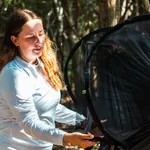 Survival skills on a desert island, woman using mosquito net in jungle.