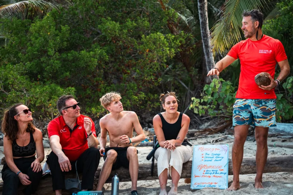 Survival outdoor training on a tropical island beach with instructor and participants.