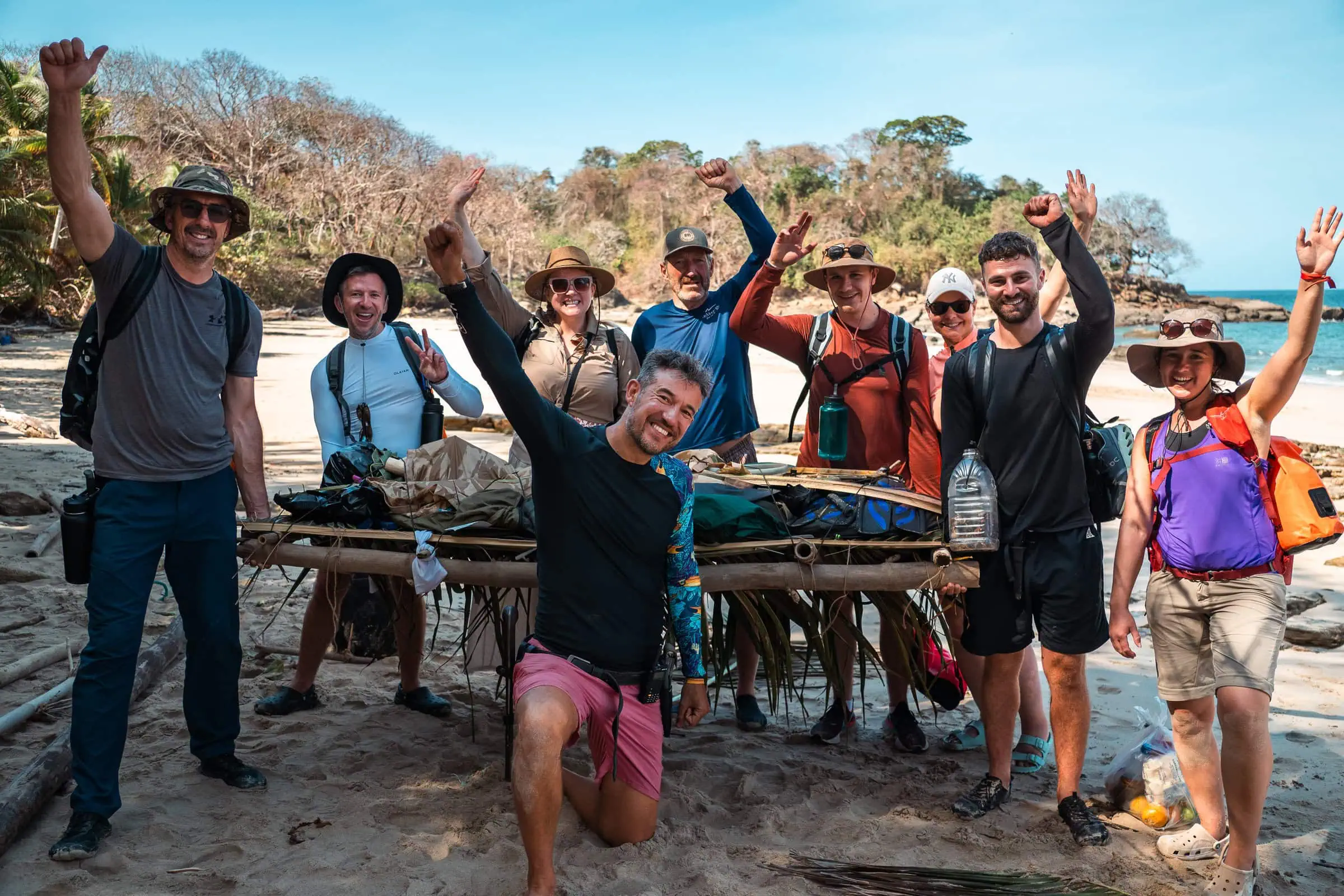 Survivors of a desert island adventure celebrating their resilience and teamwork during a survival challenge on a remote beach with tropical scenery.