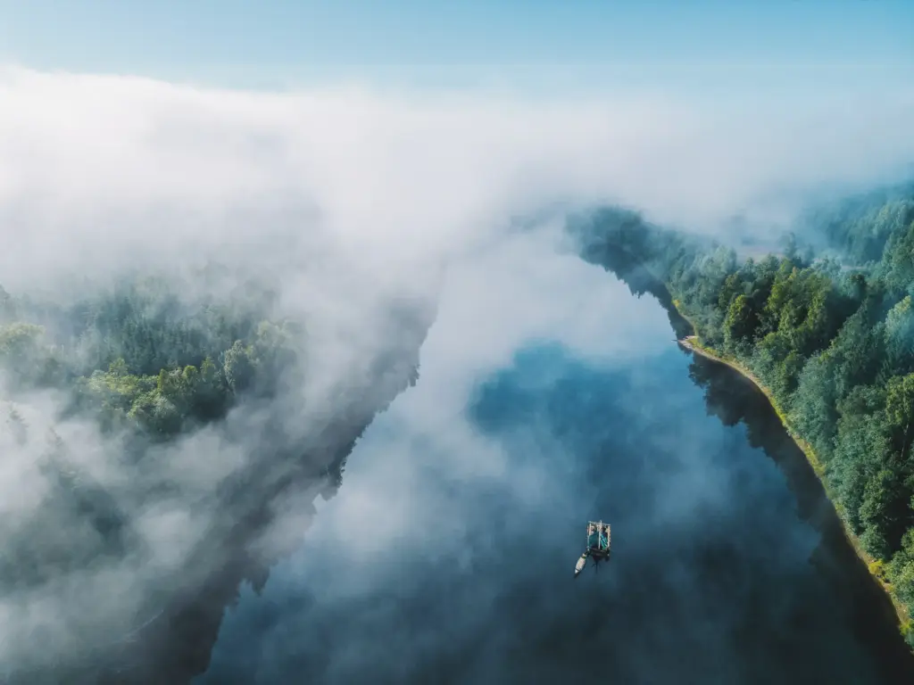 Rafting on a misty lake surrounded by forest. Building a raft with mates for a fun weekend adventure.