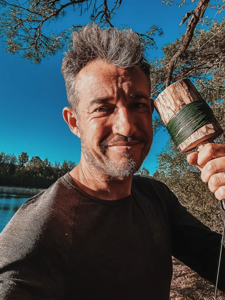 Man with hand fishing reel in Sweden wilderness setting.